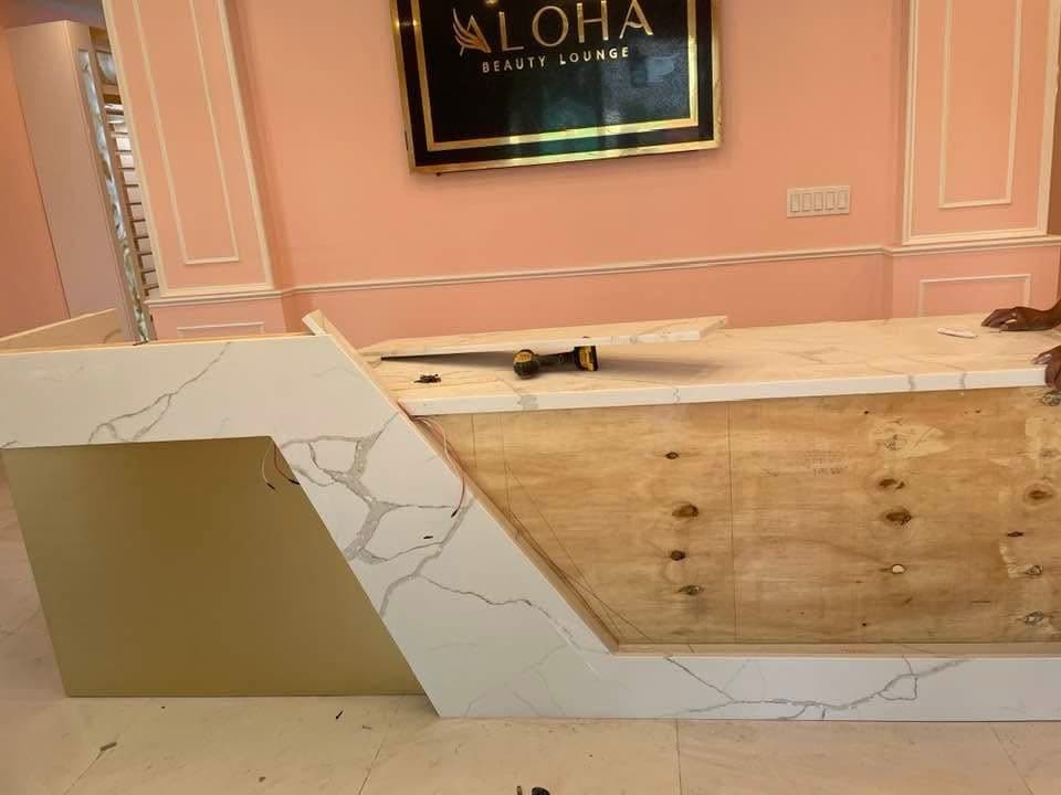 Mostrador de recepción con el panel dorado suelto y el contrachapado a la vista, antes de terminar