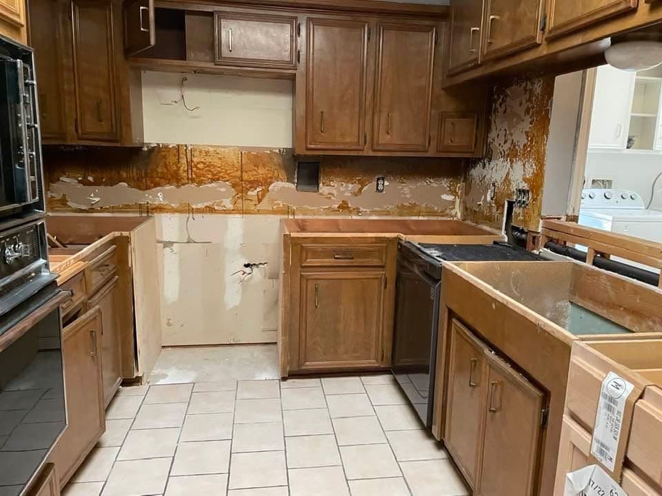 Cocina con el respaldo de pared retirado, sin encimera, antes de la remodelación